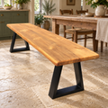 Light oak finish flat-edge wooden dining bench with black A-frame legs, styled in a country home